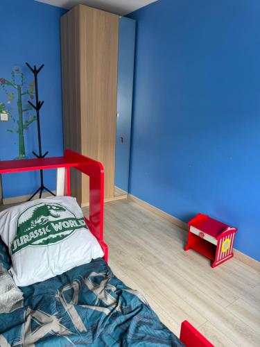 une chambre avec un lit superposé rouge et un mur bleu dans l'établissement Ananas Souriant, nearby Paris,Disneyland,Outlet, à Fontenay-sous-Bois