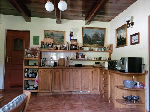 a large kitchen with wooden cabinets in a room at Domek na Obidzy in Piwniczna-Zdrój