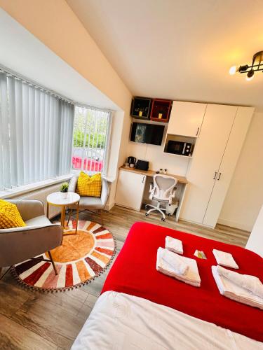 a bedroom with a red bed and a living room at Newly Renovated En-Suite Private Room in Birmingham Selly Oak R1 in Birmingham