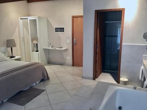 1 dormitorio con cama, bañera y lavamanos en Hotel Fazenda Santa Monica, en Louveira