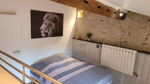 une chambre avec un lit et un tableau au mur dans l'établissement Le Moulin du Gué en Vendée Gite atypique et exceptionnel de 15 personnes au bord de l'eau à 30 minutes du PuyduFou, à Sainte-Cécile