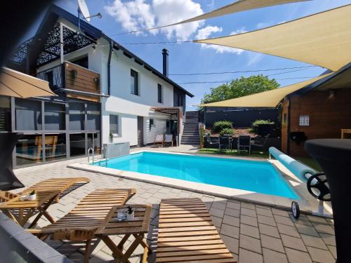 una piscina con sillas y una casa en Aura Lux Holiday Home with Pool en Lopatinec