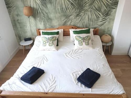 a large white bed with pillows on top of it at Oasis au Chenal - Proche Plage in Grand-Fort-Philippe