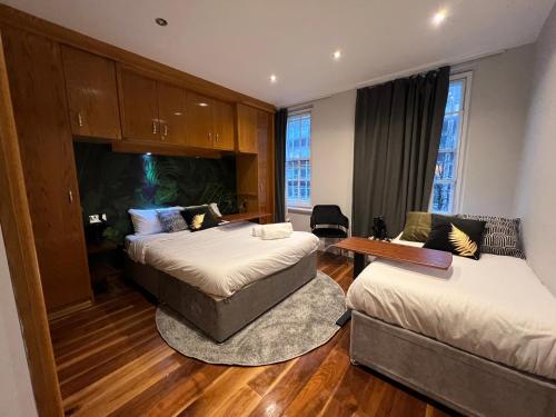 pokój hotelowy z 2 łóżkami i kanapą w obiekcie Luxe - Hyde Park - 2Bed 3Bath A/C + Lift w Londynie