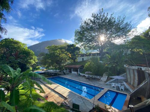 una piscina resort con una montaña en el fondo en FLAT 234 Hotel Pedra Rodeadouro, en Bonito