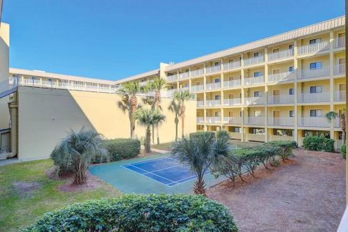 an apartment building with a tennis court in front of it at Resort Daze-2 Bedroom, Short Walk to the Beach in Hilton Head Island
