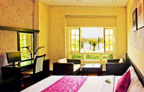 a bedroom with a bed and a living room at Le Dung Hotel & Spa in Tam Ky