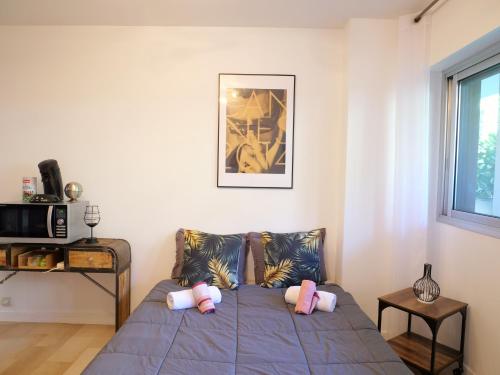 a bedroom with a bed with pink pillows on it at Studio centre de Cannes in Cannes