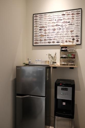 a kitchen with a refrigerator and a picture on the wall at Fish Tears B&B in Magong