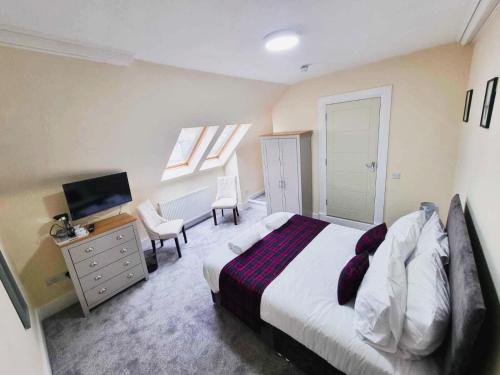 a bedroom with a bed and a desk and a television at Jacobite house in Inverness
