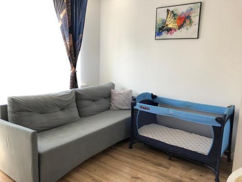 a couch with a baby crib in a living room at Apartamenty Harnaś in Rytro