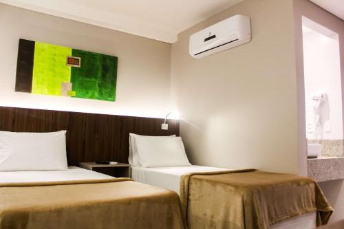 a hotel room with two beds and a window at Smart Hotel João Pessoa in João Pessoa