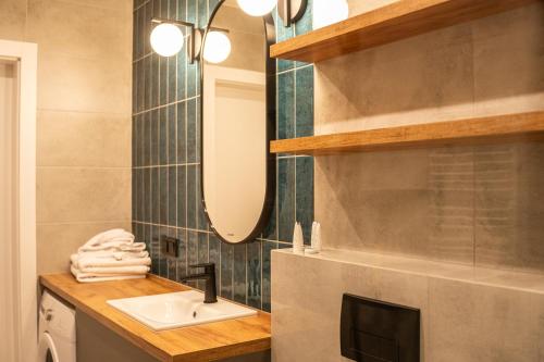 un baño con lavabo y espejo en Apartamenty Lesko 38, en Lesko