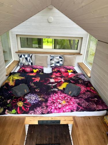 Una cama en medio de una habitación con flores en Pod strání 1 en Kníničky
