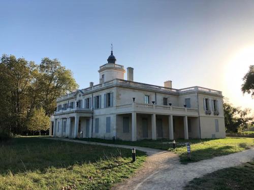 een groot wit huis bovenop een veld bij La Casa d'Audenge in Audenge