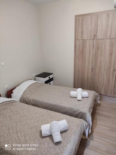 2 Betten in einem Zimmer mit Handtüchern darauf in der Unterkunft Kalipso home in Mytilini