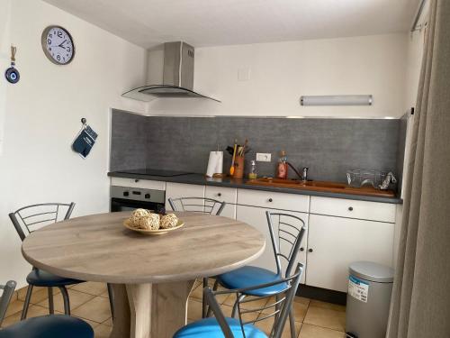 une cuisine avec une table et des chaises dans une cuisine dans l'établissement Aux Trois Gîtes, à La Chapelle