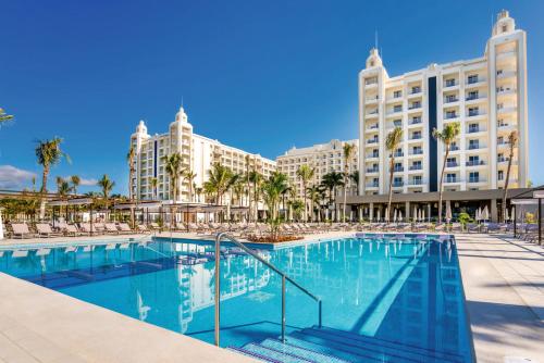 a swimming pool in front of a large building at Riu Vallarta - All Inclusive in Bucerías
