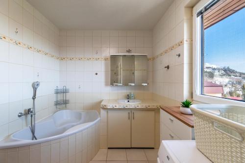 La salle de bains est pourvue d'une grande baignoire et d'un lavabo. dans l'établissement Sherpa's Hostel High Tatras, à Tatranska Strba