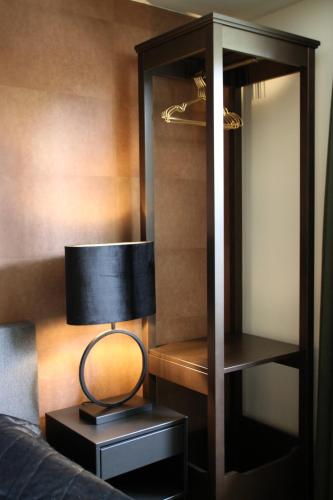 a lamp on a night stand next to a closet at Huisje Wenum - Apeldoorn met jacuzzi in Wenum