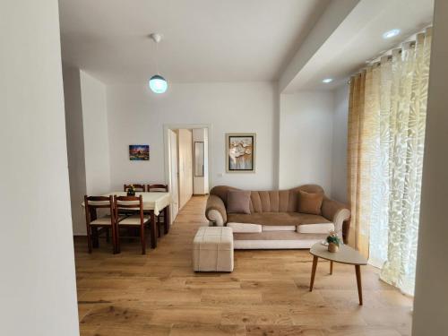 een woonkamer met een bank en een tafel bij Properhome Saranda in Sarandë