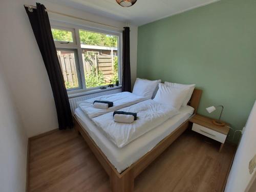 Un dormitorio con una cama con dos bolsas. en Vakantiehuis op rustig bospark Veluwe en Voorthuizen