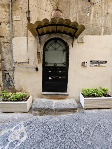 une porte noire sur le côté d'un bâtiment dans l'établissement SAN BIAGIO HOUSE, à Naples