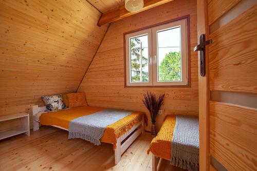 a bedroom with two beds in a wooden cabin at Stilo Country Dargobądz in Wolin