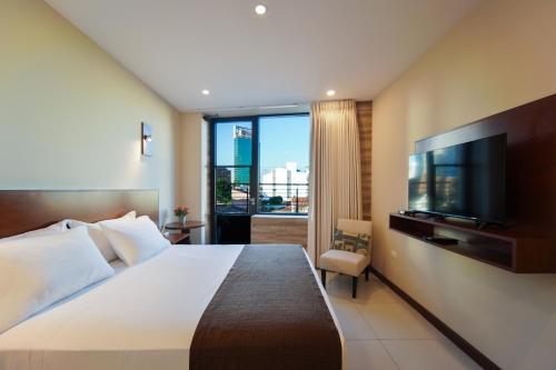 サンタ・クルス・デ・ラ・シエラにあるChairu Eco Hotelの大型ベッド1台、薄型テレビが備わるホテルルームです。