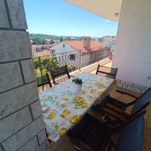 a table on a balcony with a view of the city at Luna 31 in Portorož