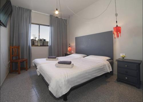 Un dormitorio con una cama grande con dos toallas encima. en casa la vida loca 007, en Playa Calera