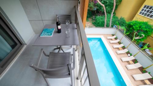 a small balcony with a table and chairs next to a swimming pool at Bomo Suites in Antalya