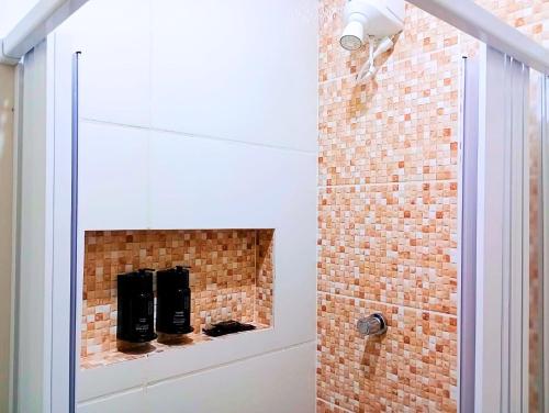 a walk in shower with a brick wall at Nomad - Norte Sul, Cambui in Campinas