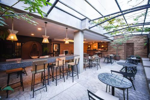 un patio al aire libre con mesas y sillas y un bar en Chairu Eco Hotel en Santa Cruz de la Sierra