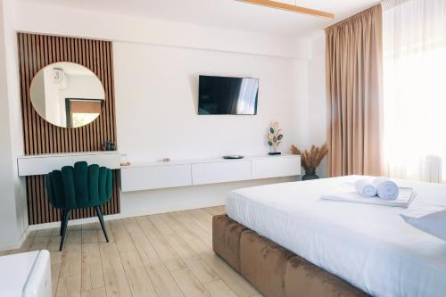 a white bedroom with a large bed and a mirror at Villa Twins Techirghiol in Techirghiol