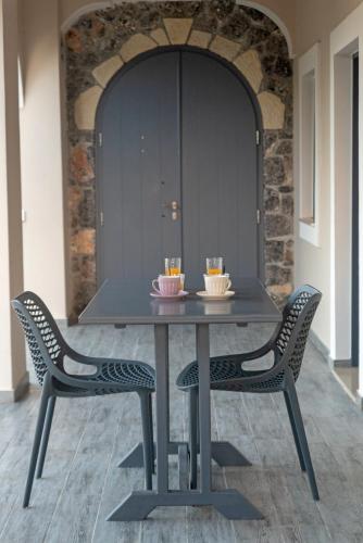 a table and two chairs with drinks on it at Carpe Diem Moursia Studio in Liapades