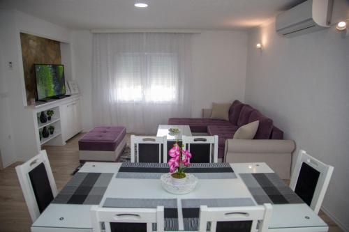 a living room with a table and a couch at Apartment Garden in Blagaj