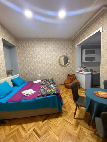 a bedroom with a bed and a table at Anna'S Home in Kutaisi