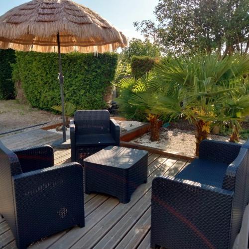 a deck with chairs and a table and an umbrella at le jack in Mont-sous-Vaudrey