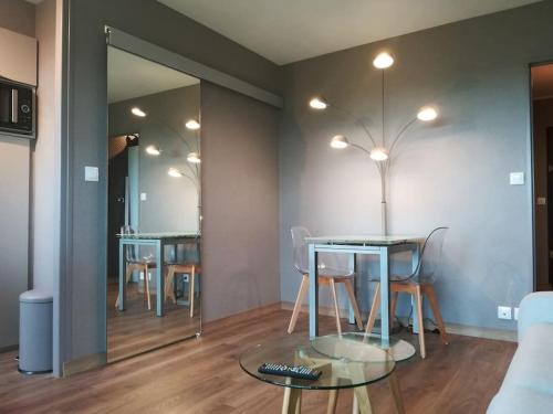 卡布尔Studio cosy vue mer avec accès direct à la plage séjour de 2 nuits minimum的一间有桌子、椅子和镜子的餐厅