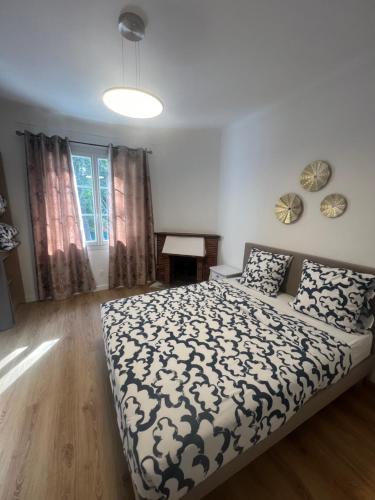 une chambre avec un lit avec une couette noire et blanche dans l'établissement Le refuge du littoral n1, à Grimaud