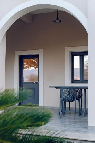a patio with two chairs and a table next to a door at Carpe Diem Moursia Studio in Liapades