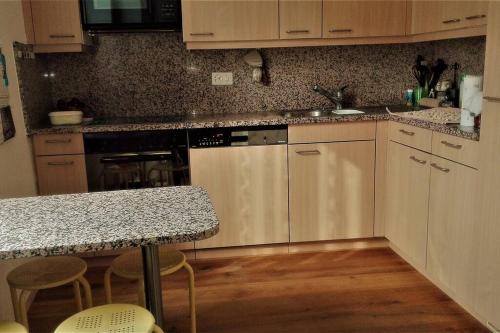 Una cocina con gabinetes blancos y encimera. en Fairy housing unit at 10 minutes drive from Lugano, en Grancia
