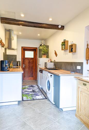une cuisine avec laveuse et sécheuse dans l'établissement La Fermette vosgienne de la Goutte, à Steige