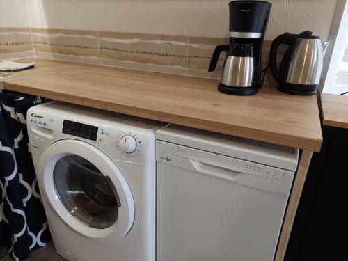 a kitchen with a washing machine and a counter at Les Meublés des Pierres Dorées - Gite de charme pour groupe in Theizé