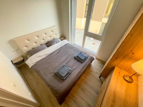 sypialnia z dużym łóżkiem i dużym oknem w obiekcie Duneville Apartments Mano Jūra 2 w Połądze