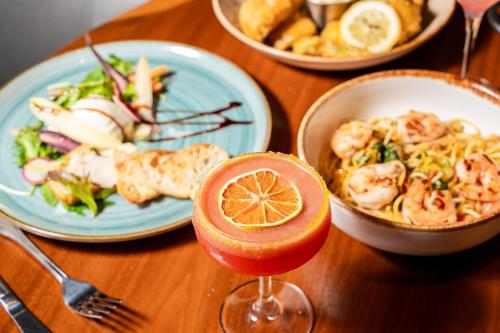 a table topped with plates of food and a drink at Le Meridien Houston Downtown in Houston