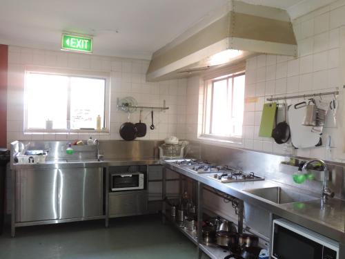 a large kitchen with stainless steel appliances and windows at Victoria Park Lodge in Perth