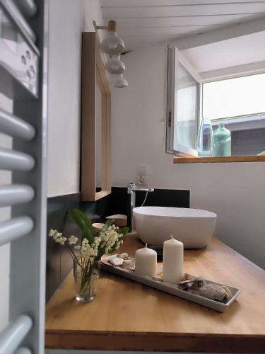 La salle de bains est pourvue d'un lavabo et d'une table avec des bougies. dans l'établissement Ancien hôtel baie Saint-Michel-en-Grève, à Saint-Michel-en-Grève