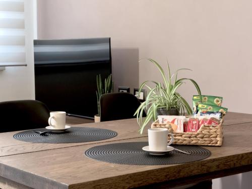 Una mesa de comedor con dos tazas y una canasta de comida. en Berni Apartments, en Verona